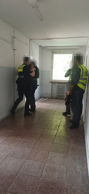 Trainingsszene im Gebäude: Polizeikräfte und Trainer mit Warnweste bei einer Zugriffsübung